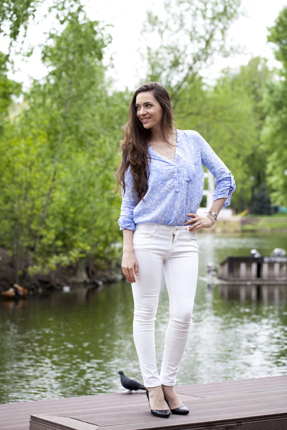 Full length portrait of a beautiful woman in white pants and blu - Foto, imagen