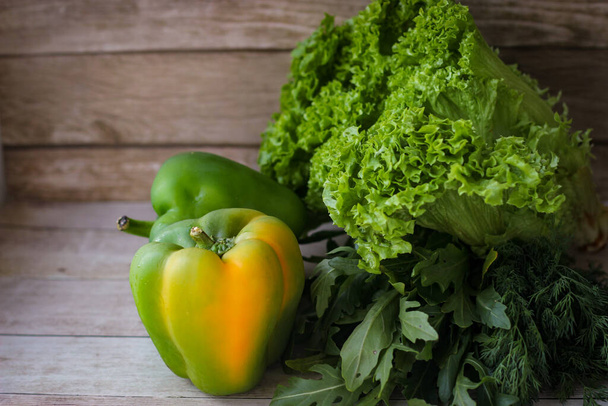 Terveellisen ruokavalion käsite. Vihreä tilli lehdet ja arugula, ja salaatti sekä vihreä paprika puinen tausta - Valokuva, kuva