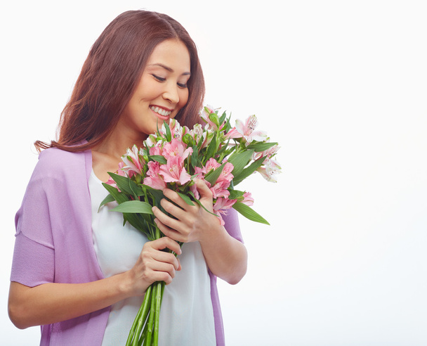 Frau blickt auf Blumen - Foto, Bild