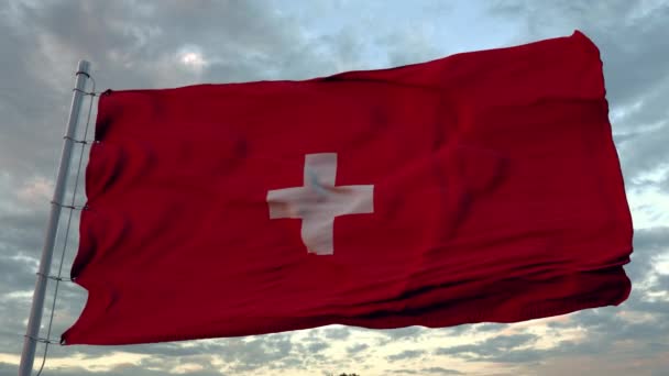 Sveitsin lippu lepattaa tuulessa sinistä taivasta vasten. - Materiaali, video
