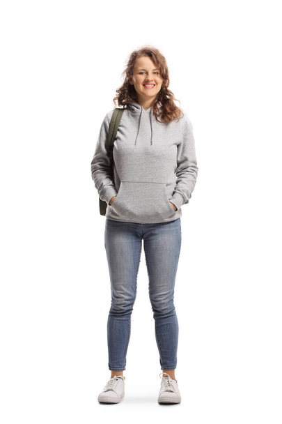 Full length portrait of a female student standing and smiling at the camera isolated on white background - Foto, afbeelding