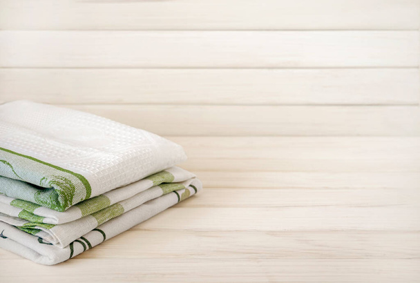 Una pila di asciugamani ordinatamente piegati su uno sfondo di legno. Produzione di fibre tessili naturali. Prodotto biologico. Materiali naturali. - Foto, immagini