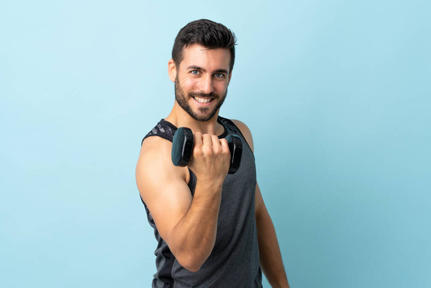 Young sport man with beard making weightlifting with happy expression - Photo, Image