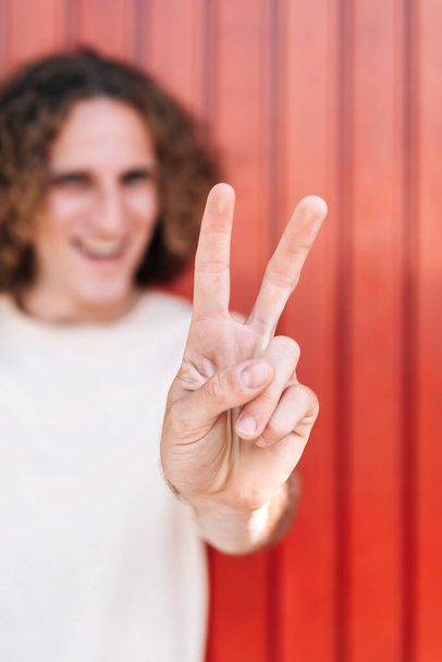 Hand gebaren op een symbool van de overwinning met twee vingers - Foto, afbeelding