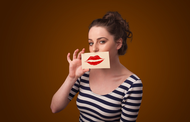 Happy pretty woman holding card with kiss lipstick mark - Foto, Imagen