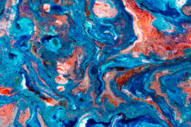 The background is acrylic blue with red lines and sparkles. Colorful marble texture. Fluid liquid marble. Art picture. Avant-garde creativity. - Photo, Image