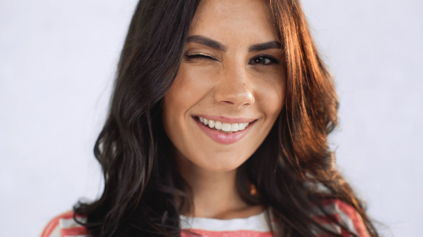 close up of cheerful and brunette woman winking eye while looking at camera  - Photo, Image