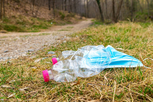 Πλαστικά μπουκάλια ρίχνονται στην κοίτη ενός ρυακιού, επιπλέοντας στο νερό. Ρύπανση. - Φωτογραφία, εικόνα