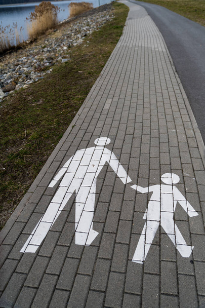 Pasarela peatonal, paseo con niño, símbolo en blanco. - Foto, Imagen
