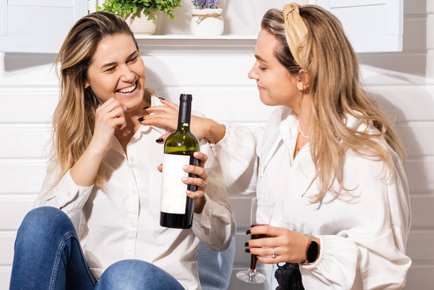 Gay couple two beautiful young women, lgbt romantic party with red wine at home, happiness, hug, family relationship - Photo, image