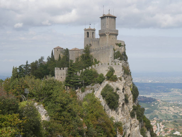 San Marino, de heksenpas. Panorama van het pad met de trap uitgehouwen in de rots naar de eerste toren op een rots met uitzicht op de omgeving en de zee  - Foto, afbeelding