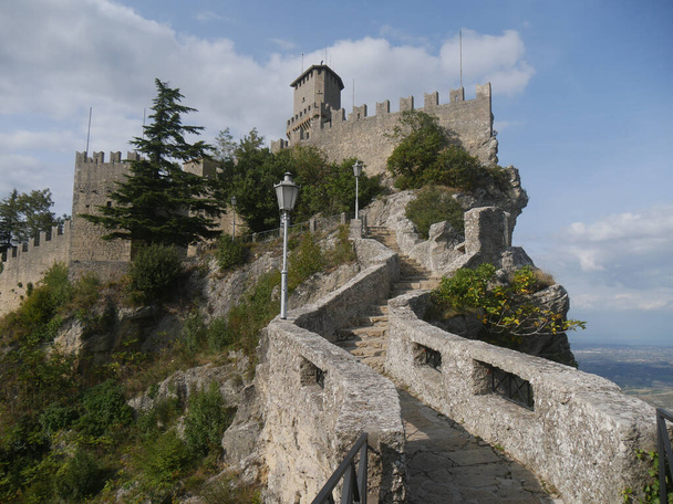 San Marino, o Passe das Bruxas. Panorama do caminho com a escada esculpida na rocha em direção à Primeira Torre empoleirada em uma rocha com vista para a área circundante e o mar  - Foto, Imagem