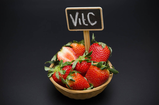 reife Erdbeere im Korb und Namensschild mit der Aufschrift Vitamin C - Foto, Bild