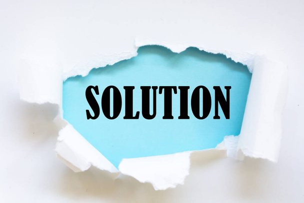Torn white paper revealing the word Solution - Photo, Image
