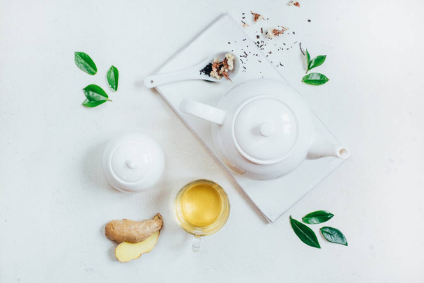 vista superior de un conjunto de utensilios de té tetera taza de azucarero con té sobre un fondo blanco - Foto, imagen