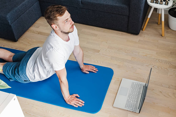 Young man doing yoga in his living room - Φωτογραφία, εικόνα