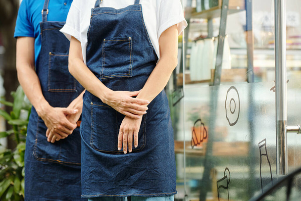 Imagen recortada de camareros o baristas en delantales parados afuera de una pequeña cafetería o cafetería - Foto, Imagen