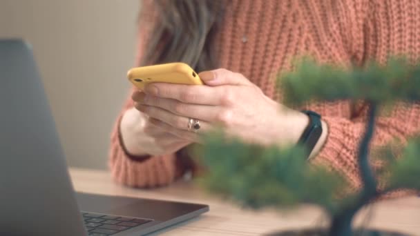 Close up filmato donna in ufficio digitando messaggio su smartphone - Filmati, video