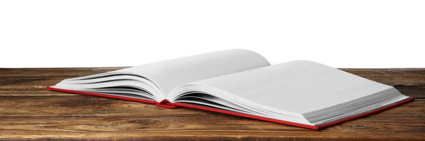 Open book with red cover on wooden table against white background - Foto, immagini
