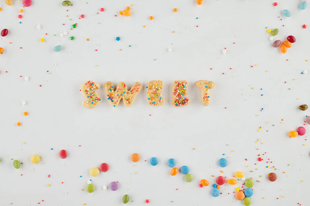 Woord zoet gemaakt van heerlijke zelfgemaakte koekjes en versierd met regenboog hagelslag - Foto, afbeelding