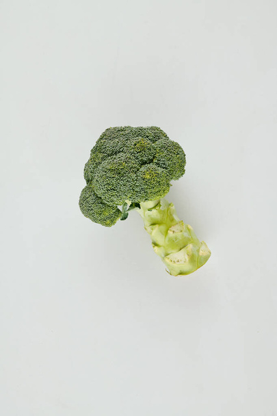 Fresh organic broccoli head on light grey background, view from above - Photo, Image