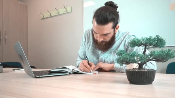 Nagranie pracownika biurowego robiącego notatki w swoim codziennym programie - Materiał filmowy, wideo