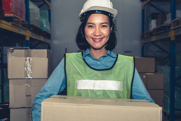 Retrato de una joven mujer asiática trabajadora de almacén sonriendo en el almacén - Foto, imagen