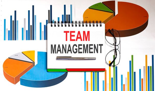 Text TEAM MANAGEMENT on notepad with office tools, pen on financial report - Valokuva, kuva