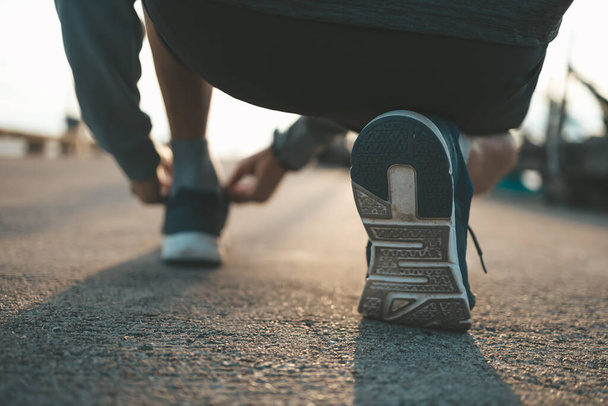 closeup of shoe laces on the road before running in sunset. Sport and workout concept. - Foto, imagen