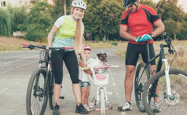 спортивная семья проводит велосипеды в городе на стадионе - Фото, изображение