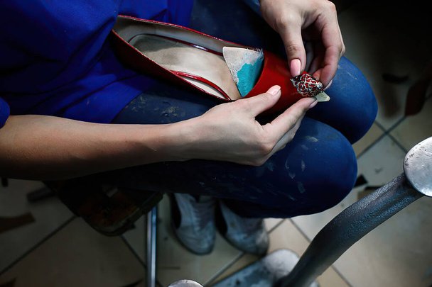 mujer trabaja en un taller de reparación de zapatos, vista desde arriba - Foto, imagen