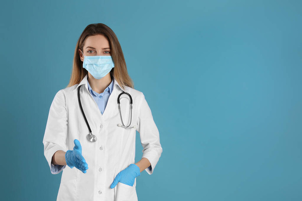 Doctor in protective mask and gloves offering handshake on light blue background. Space for text - Fotoğraf, Görsel