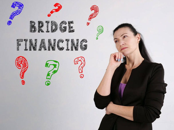 Üzleti koncepció: BRIDGE FINANCING kérdőjelek felirattal a falon - Fotó, kép