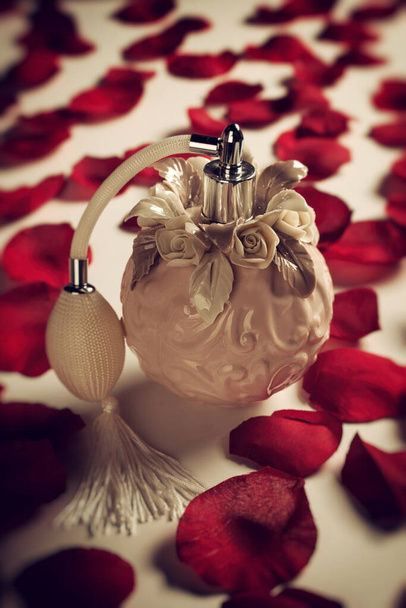 Perfume bottle on red rose petals, concept of love and passion. - Photo, Image
