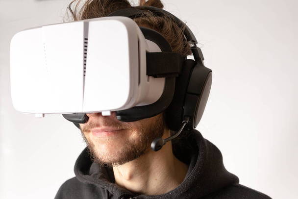 Крупный план неизвестного мужчины в VR гарнитуре и испытывающего виртуальную реальность. Мбаппе, концепция виртуальной реальности, игр, электронных видов спорта - Фото, изображение