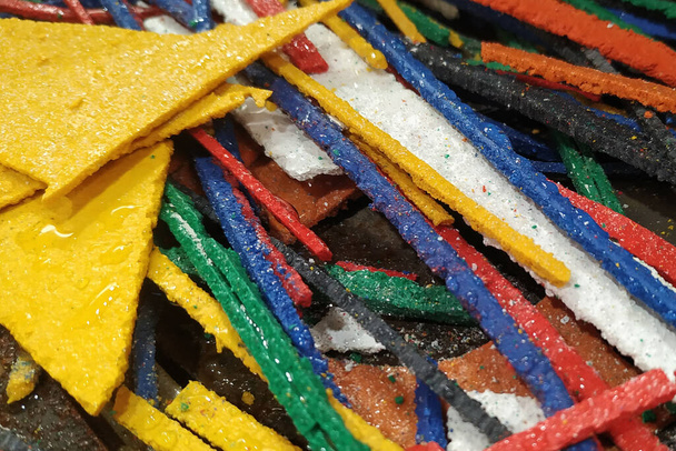 Afval van gekleurd decoratief materiaal in de vorm van restjes op de watersnijmachine - Foto, afbeelding