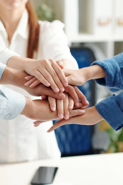 Business people stacking hands to express support, unity and team spirit before starting work on big project - Photo, Image