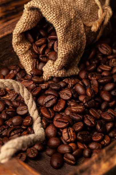 Roasted coffee beans on the old dark wooden background for wallpaper or decor. - Fotografie, Obrázek