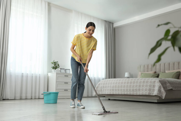 Woman cleaning floor with mop at home - Fotoğraf, Görsel