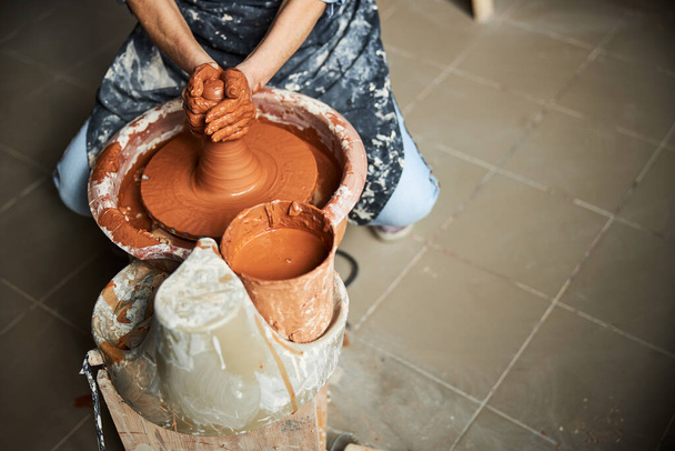 Kıdemli kadın elleri çömlek atölyesinde kilden ot yapıyor. - Fotoğraf, Görsel