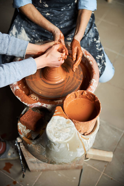 Manos de alfarero haciendo olla de arcilla en taller - Foto, Imagen