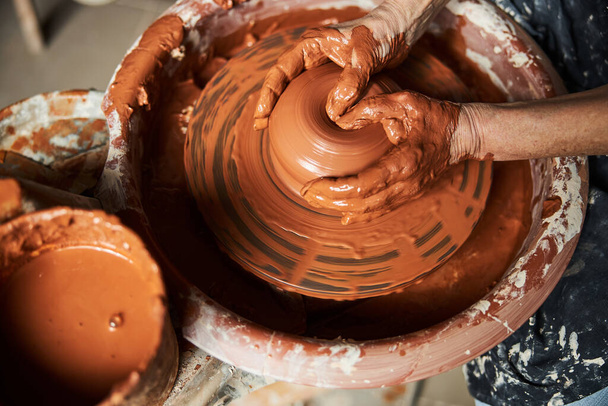 陶器の車輪の上に粘土鍋を作るシニア女性の手 - 写真・画像