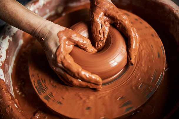 Las manos ancianas haciendo olla de barro en la rueda de cerámica - Foto, Imagen