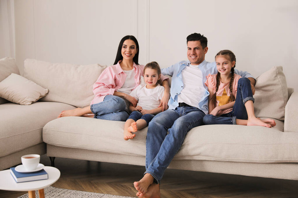 Happy family resting on comfortable sofa in living room - Foto, imagen