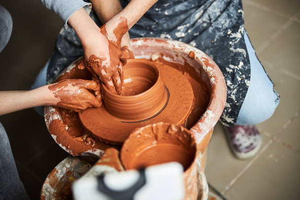 Craftspeople hands making clay pot in pottery workshop - Photo, Image