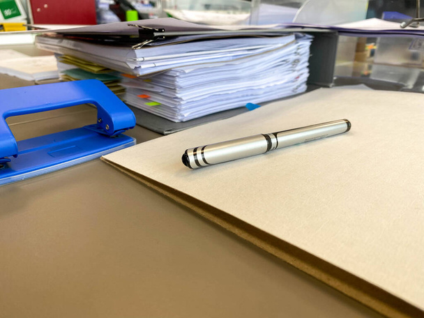 Nagy vastag mappák fontos papírokkal és dokumentumokkal egy íróasztalon írószerekkel és tartozékokkal. - Fotó, kép
