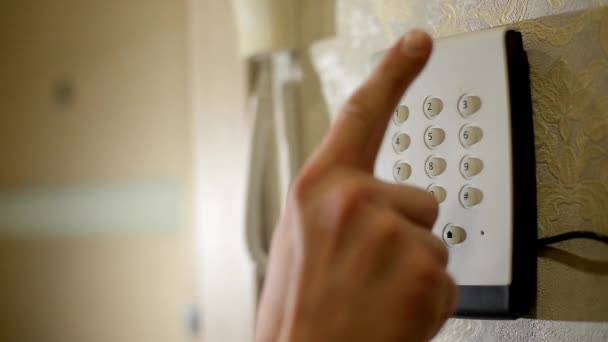 La mano dell'uomo digita il codice del sistema di sicurezza di casa su una tastiera con i numeri di furto e furto. Console di sorveglianza e protezione contro gomme e ladri. - Filmati, video