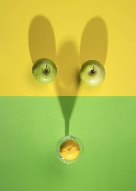 Frutas em fundo verde e amarelo, limão e maçã textura minimalista flatlay, vegan alimentos orgânicos saudáveis. - Foto, Imagem