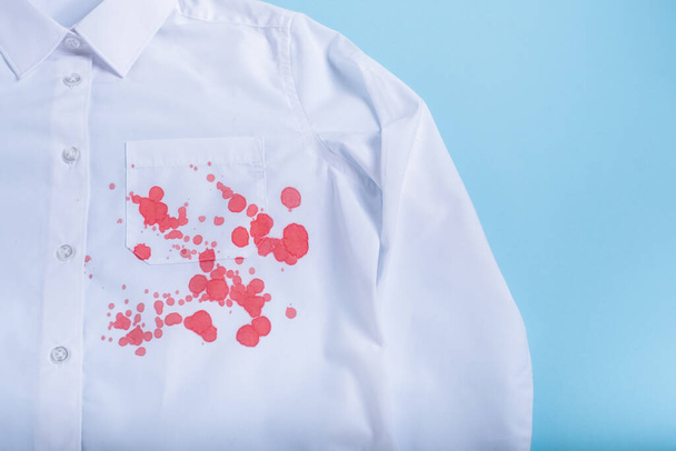 blood stain on clothes. isolated on blue background. top view. High quality photo - Photo, Image
