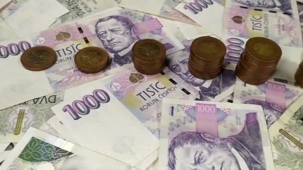 Una panoramica dettagliata delle banconote ceche da 1000 e 2000 mila su cui sono impilate cinquanta monete corona in una colonna  - Filmati, video
